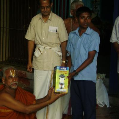 Swamigal Presenting Solar Lantern To The Student Of The Village School