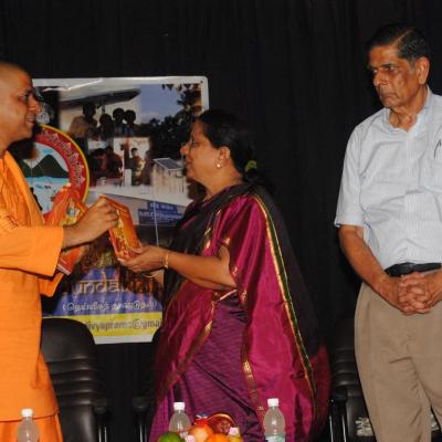 Swamiji Hands Over The First Copy To Ms. Malini Hm Pshs School